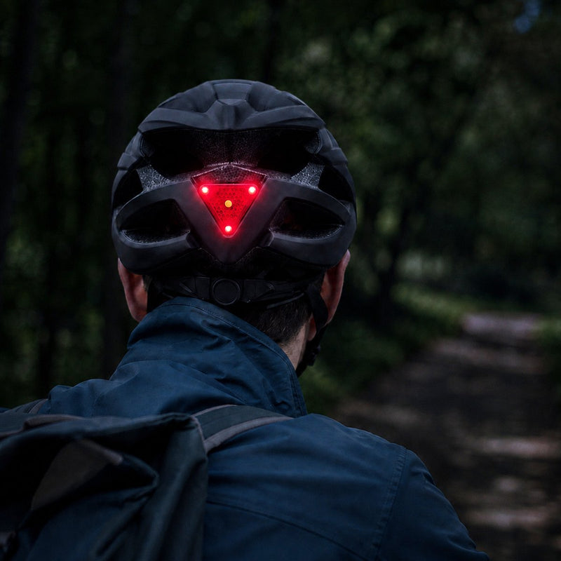 Fietser met een Travelhawk fietshelm met brandend rood achterlicht in het donker