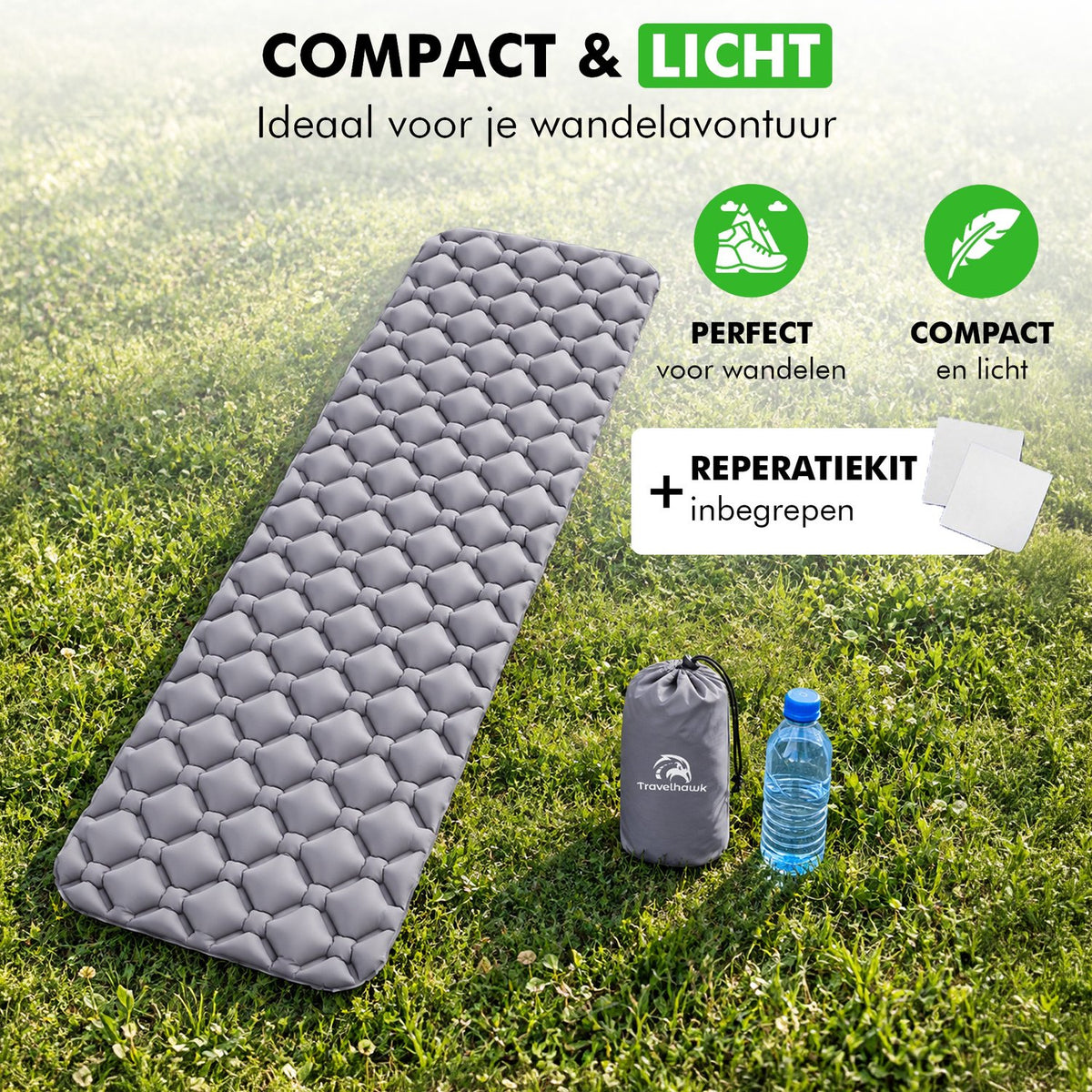 Compacte en lichte slaapmat met draagtas en reparatiekit, op het gras naast een waterfles